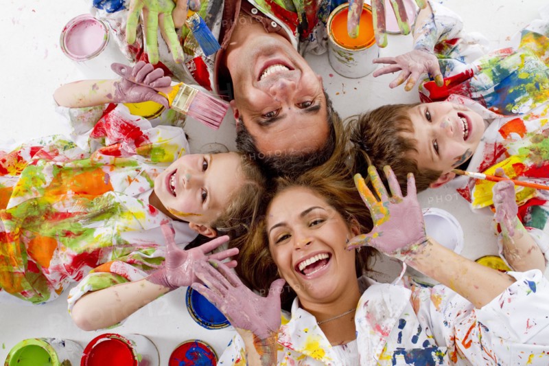 Hispanic family covered in paint laying on floor