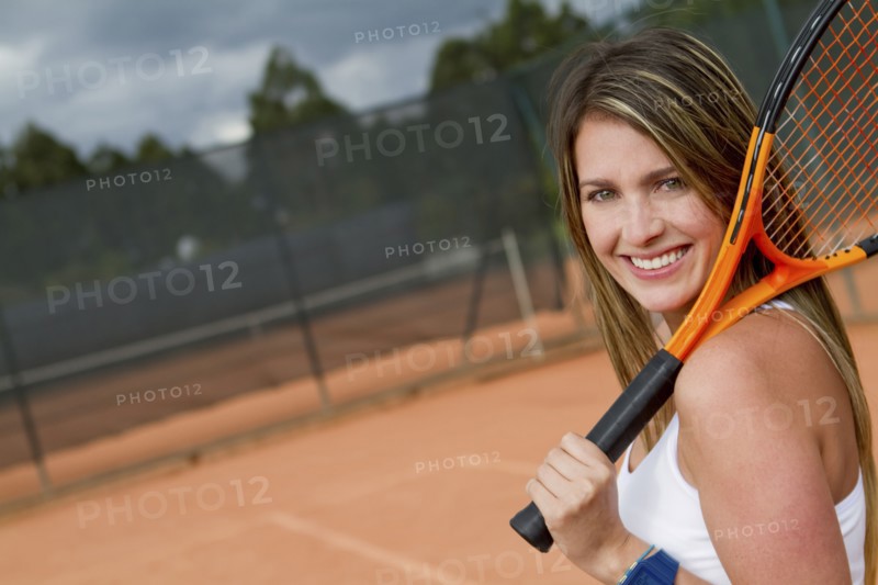 Hispanic woman holding tennis racquet on court