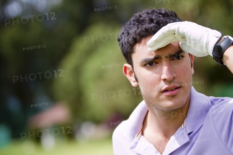 Hispanic man searching for golf ball