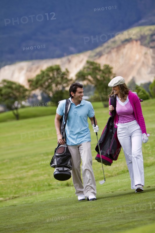 Hispanic couple playing golf together