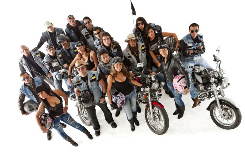 Hispanic bikers standing with motorcycles