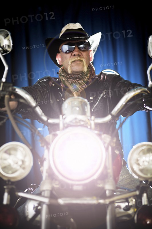 Hispanic biker sitting on motorcycle