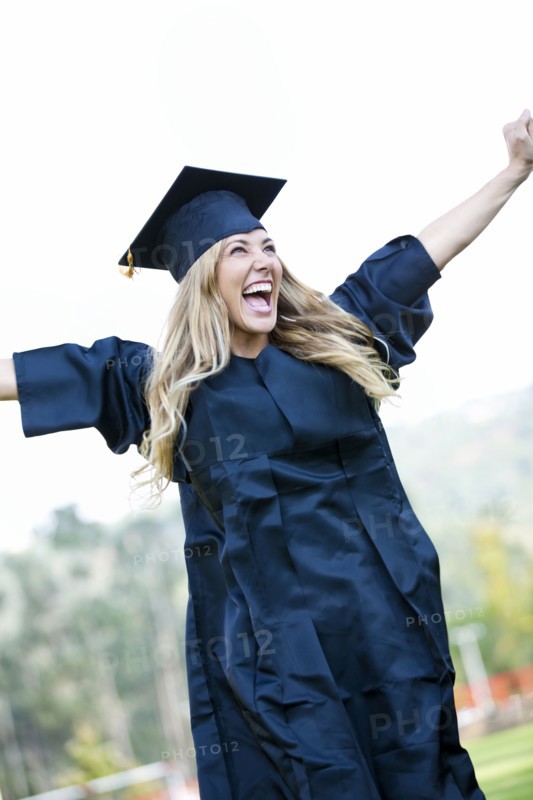 Hispanic college graduate cheering with arms raised