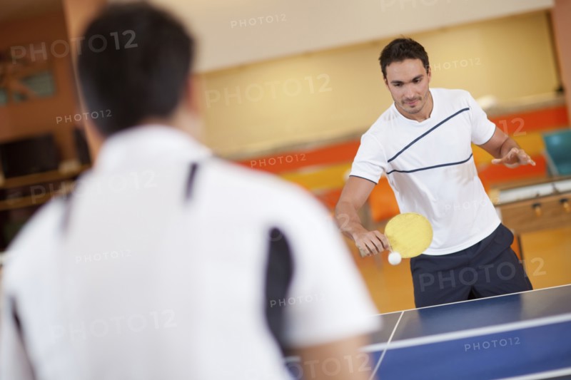 Hispanic men playing ping pong
