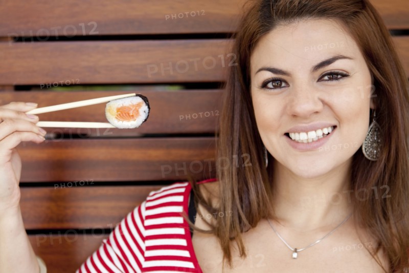 Hispanic woman smiling with sushi