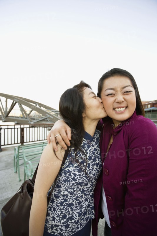 Chinese mother kissing daughter