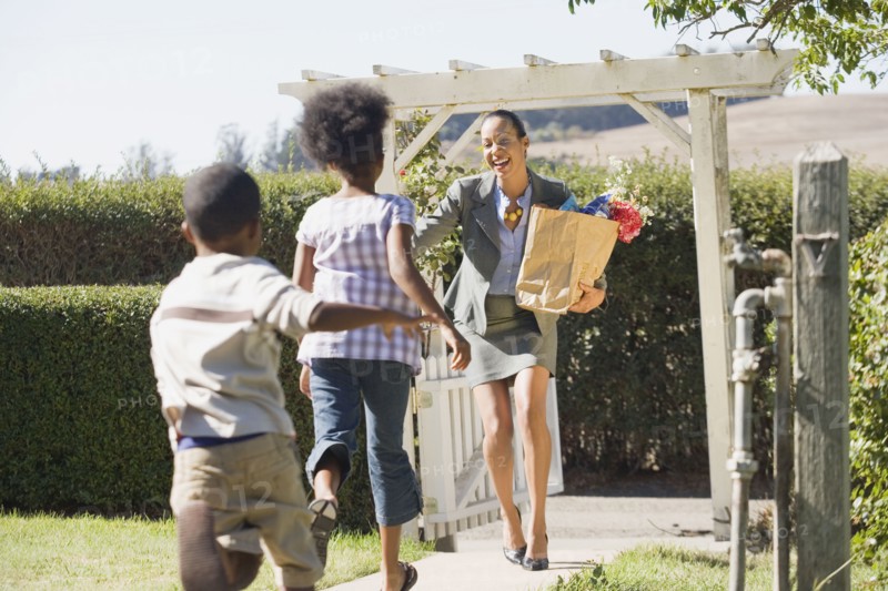 Children running to mother carry groceries