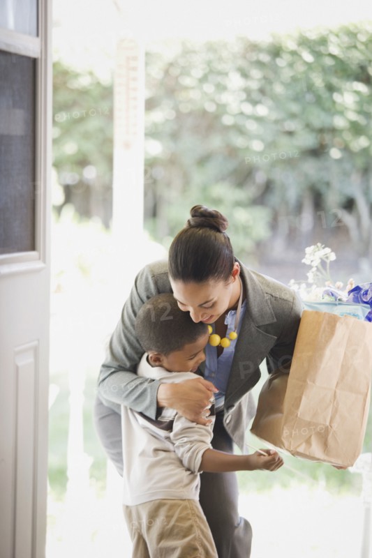 Mother with groceries hugging son
