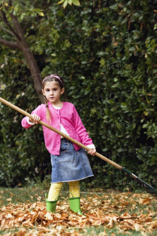 Middle Eastern girl raking leaves