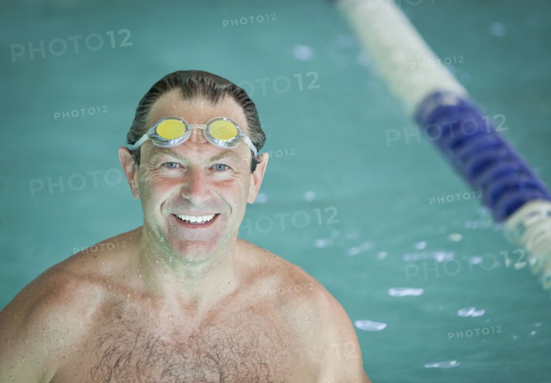Smiling man with goggles in swimming pool