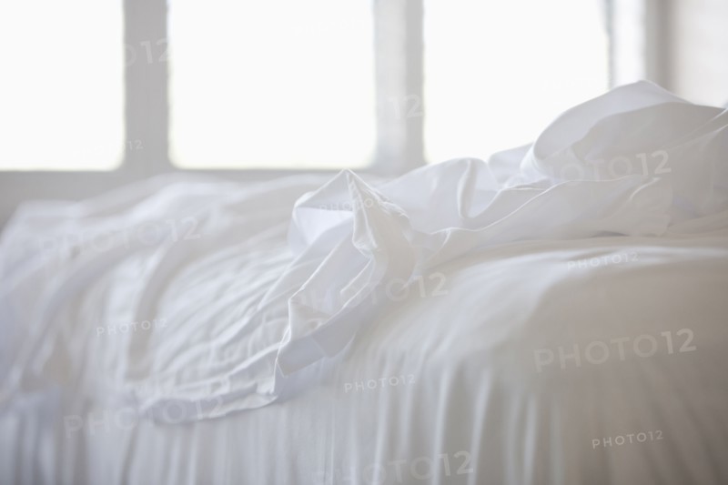 Close up of white sheets on bed