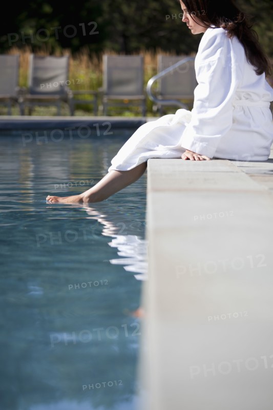 Woman soaking feet in swimming pool