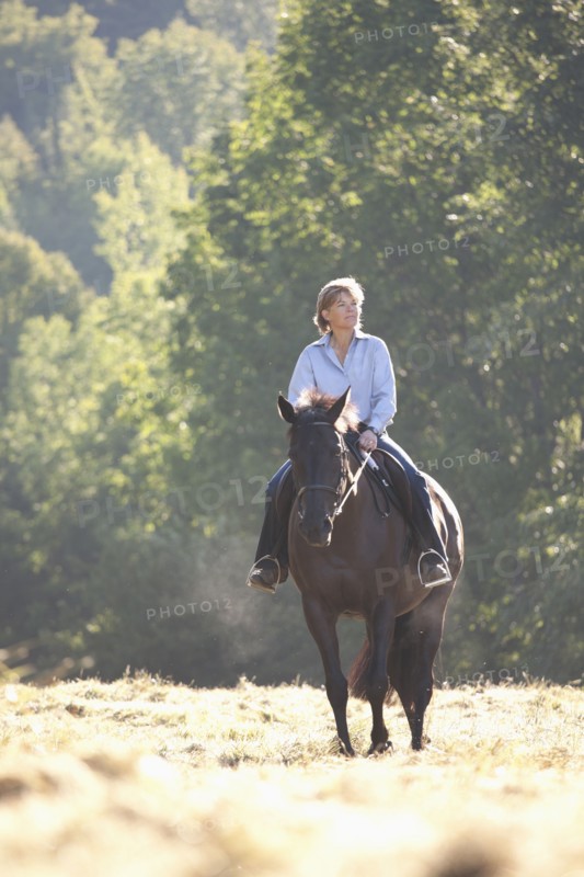 Caucasian woman riding horse in field