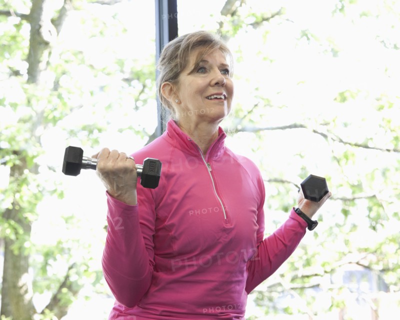 Woman lifting weights in health club