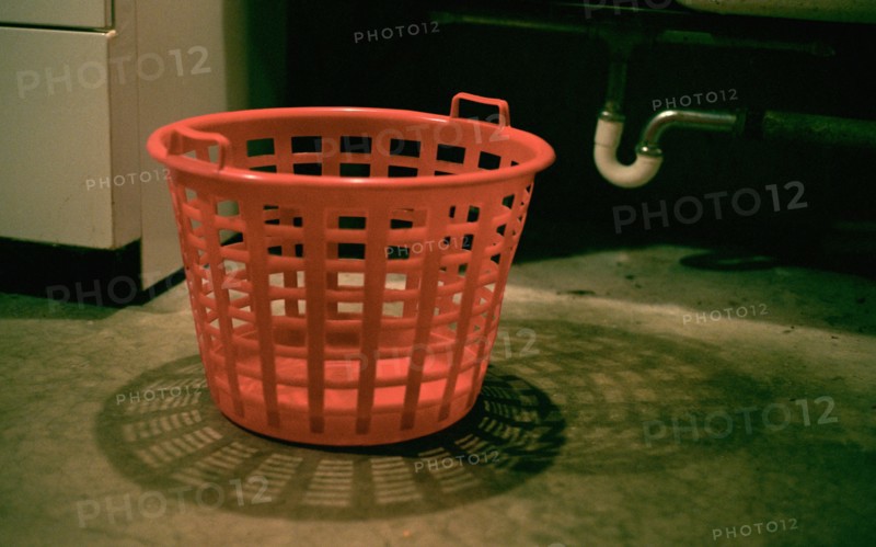 Empty laundry basket on floor in basement