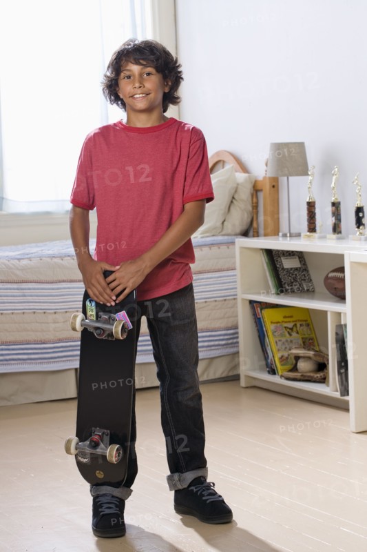 Mixed Race boy holding skateboard