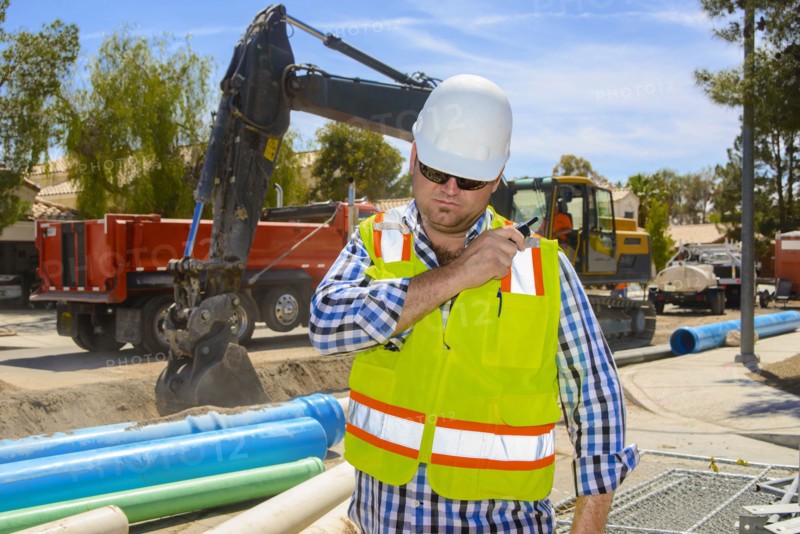 Caucasian construction worker listening to walkie-talkie