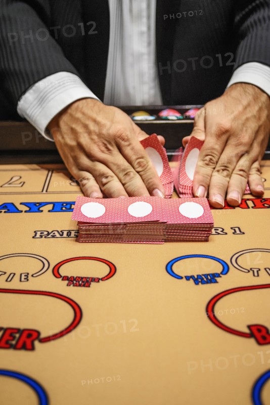 Dealer shuffling cards at baccarat table