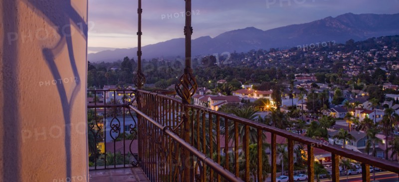 Detail wrought iron railing of balcony with sunset view of Santa Barbara