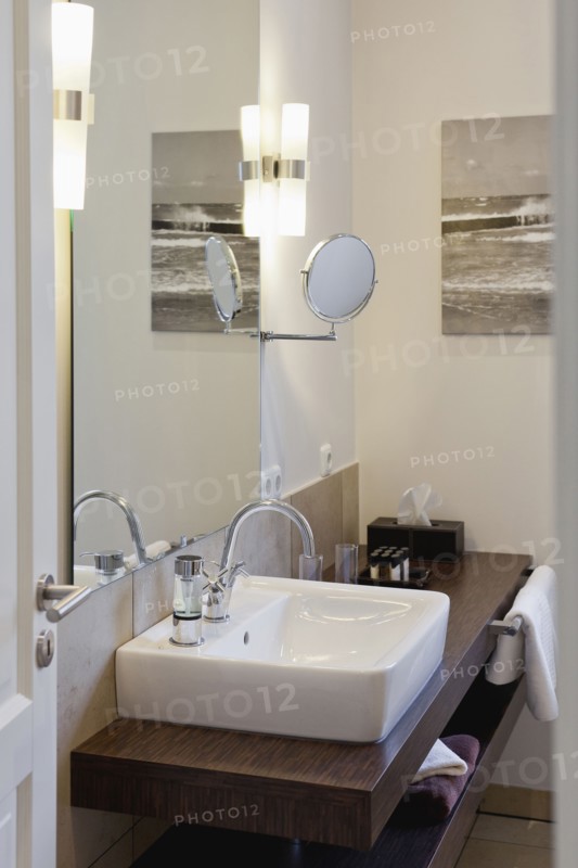 Sink on wooden countertop in domestic bathroom