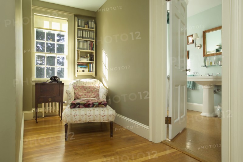 Long armchair on hardwood floor in traditional clean home