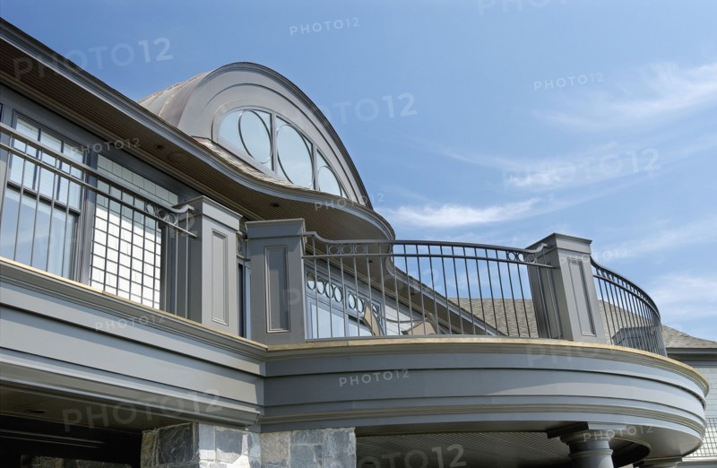 Exterior of home with round top window and balcony