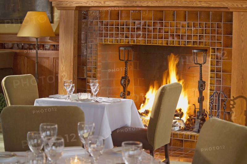 Simple dining table in front of warm fireplace