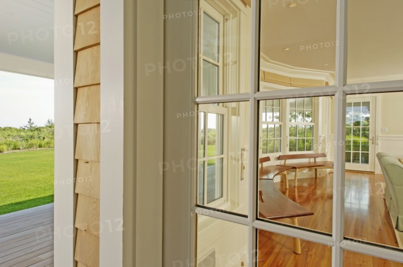 View from outside into sunroom with row of wooden benches