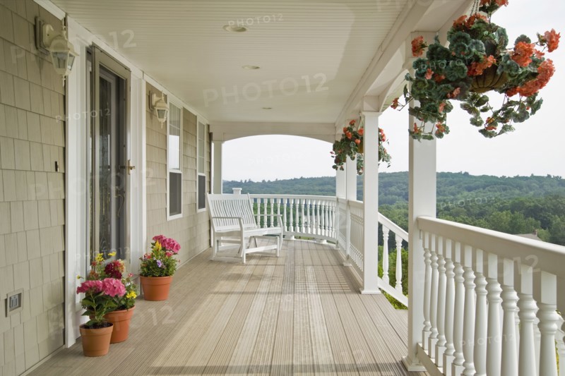 Large front porch of shingle style home with great view of tree tops