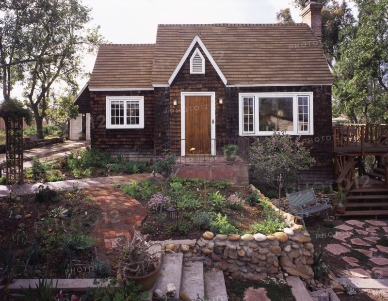 Front exterior wooden Cape Cod cottage and landscaping