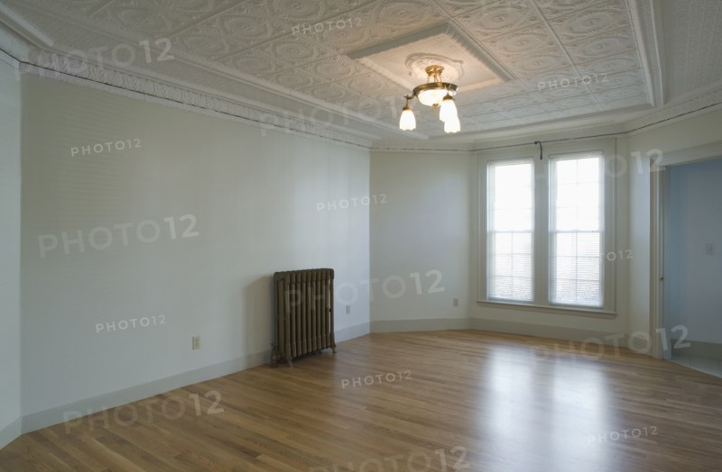 Empty room in apartment with hardwood floor and heater