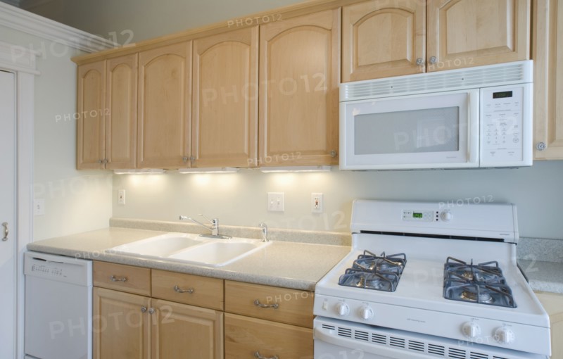 Empty kitchen with light colored cabinets