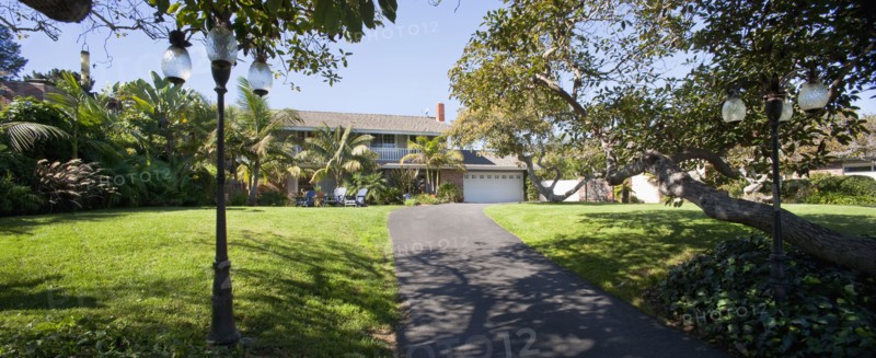Lawn with driveway leading to multiple story home