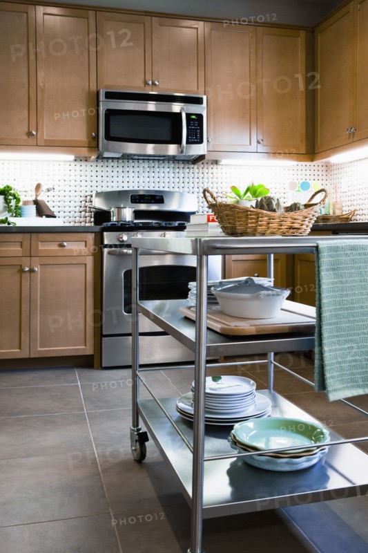 Stacks of dishes on chefs cart in domestic kitchen