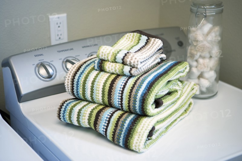 Towels folded on dryer in laundry room