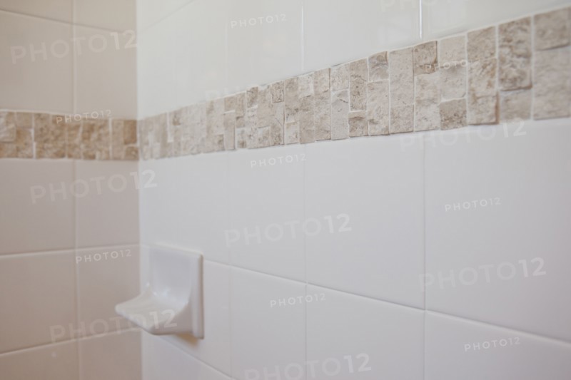 Close-up of a soap dish on tiled bathroom wall at home