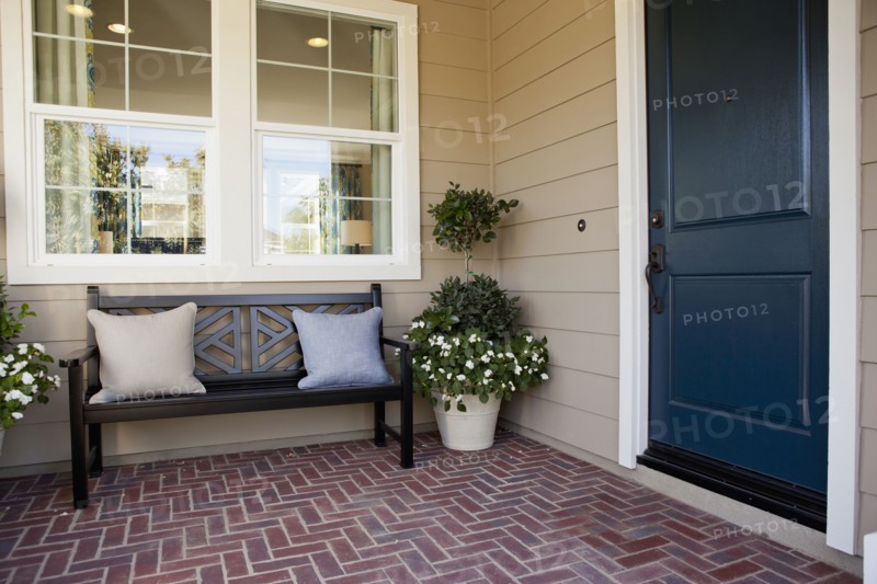 Brick flooring porch with closed door and bench