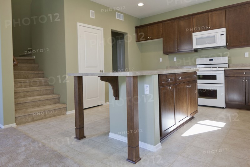 Kitchen having brown cabinets and island at home