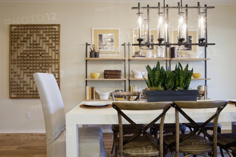 Chairs at dining table with shelves in the background at home