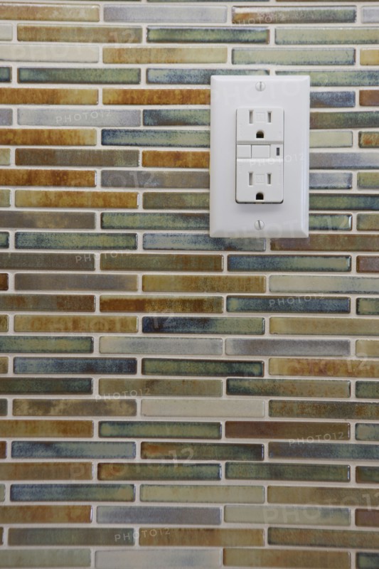 Close-up of tile backsplash with electrical socket