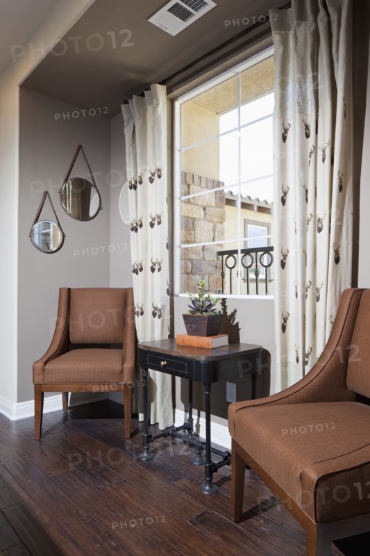 Brown chairs and end table against window