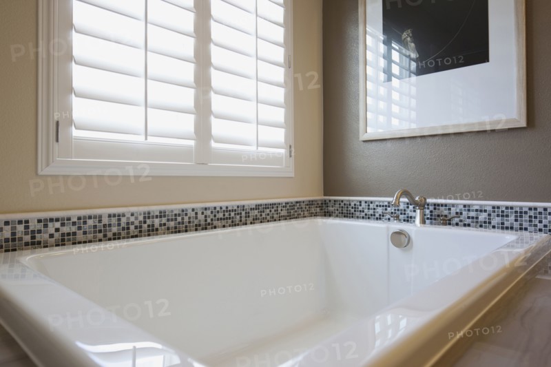 Bathtub by shutter window in master bathroom