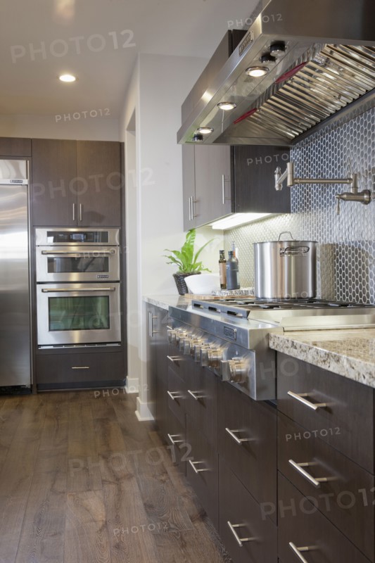 Kitchen having brown cabinets with vent hood at home