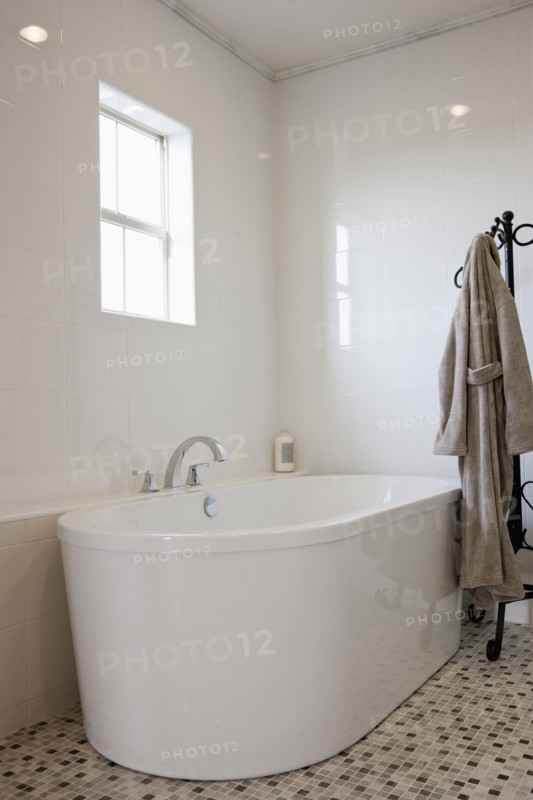 View of a bath with bathrobe on stand in the bathroom