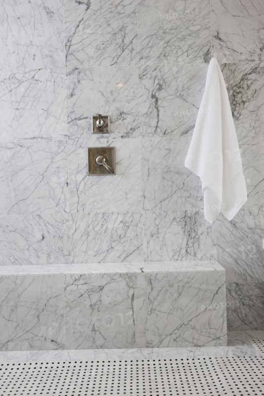 White towel and tap on marble wall in the bathroom at home
