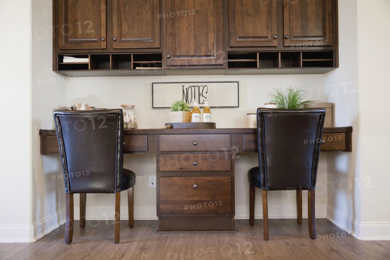 Chairs at study table with brown cabinets at home
