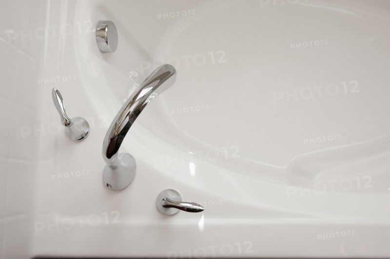 Close-up shot of faucet at cropped bathtub in the bathroom