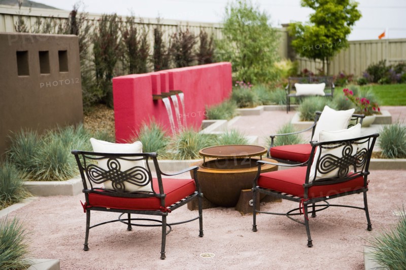 Wrought iron chairs surrounding fire pit in back yard