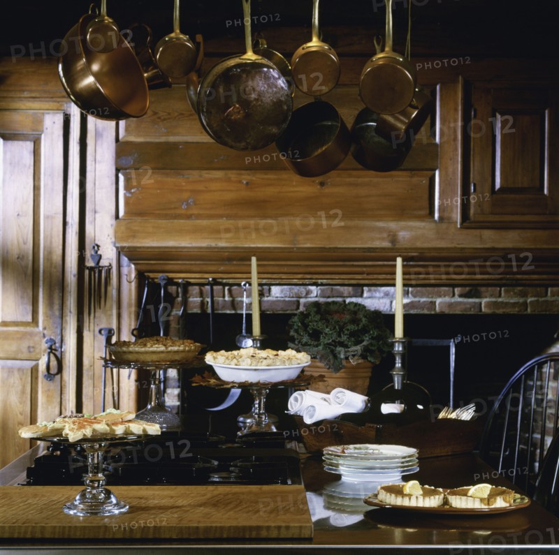 Cooking island set with desserts and antique hanging copper pots and utensils