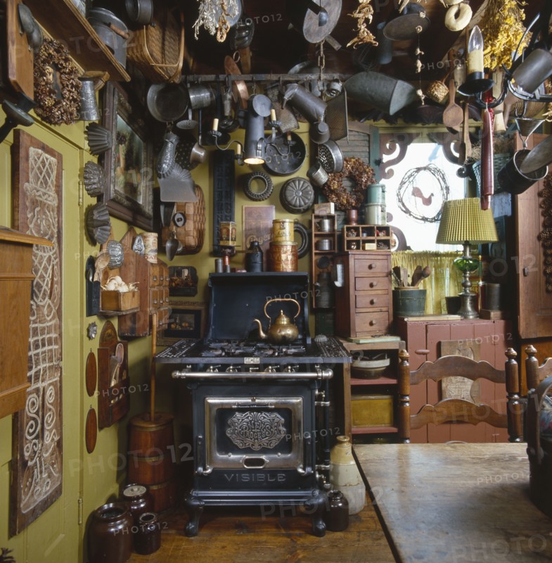 Old tin kitchen utensils and molds hanging from ceiling in country kitchen